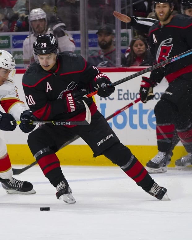 Feb 16, 2022; Raleigh, North Carolina, USA; Carolina Hurricanes center Sebastian Aho (20) skates with the puck against Florida Panthers center Anton Lundell (15) during the first period at PNC Arena. Mandatory Credit: James Guillory-USA TODAY Sports